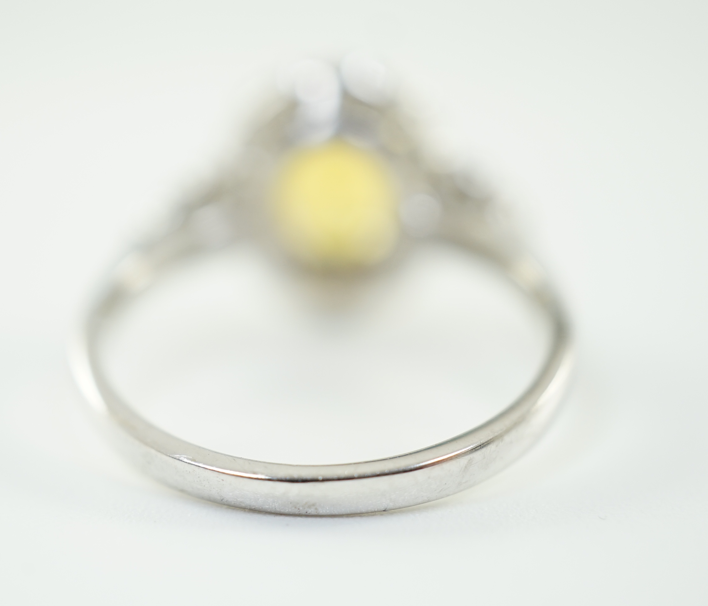 A modern 18ct white gold and single oval cut yellow sapphire set ring